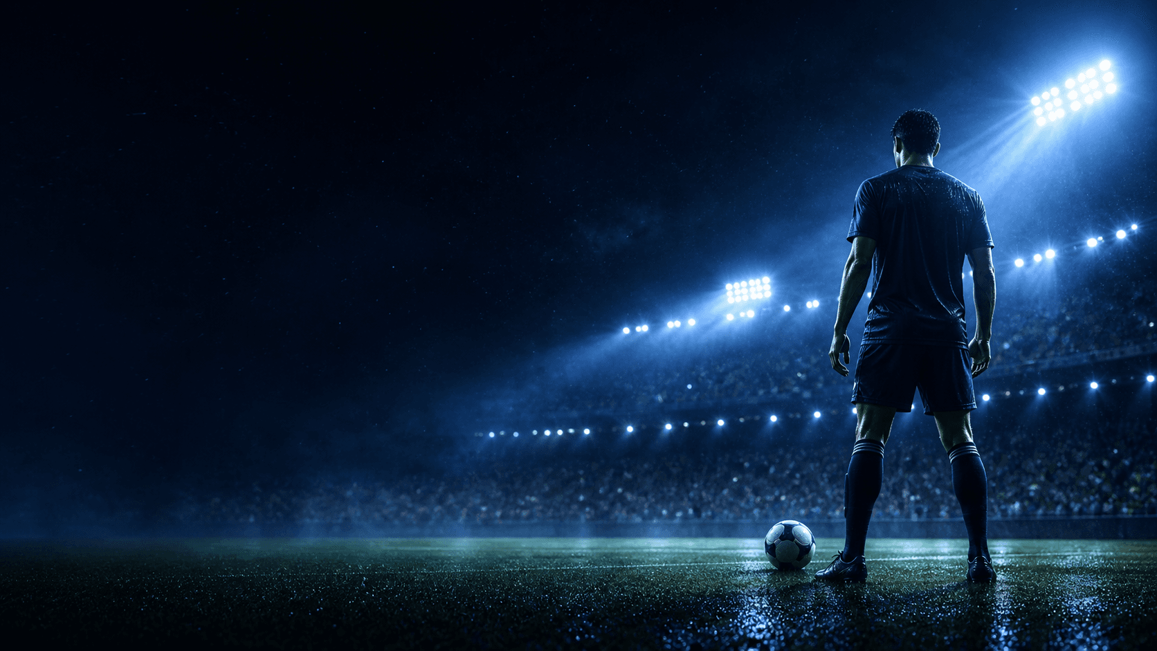 A fictional footballer on a night football pitch under blue floodlights.